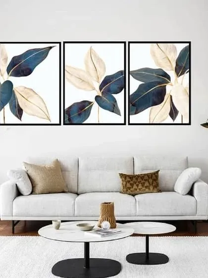 A beautiful set of three framed prints showcasing illustrative Aucuba leaves. The combination of deep blue and cream colors with delicate golden lines creates a sophisticated and elegant botanical display.