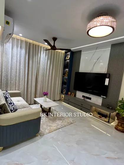 This TV unit combines a marble-finish back panel with vertical louvers for a textured, modern look. The integrated display shelves and ambient lighting make it a functional and beautiful centerpiece of the living room.