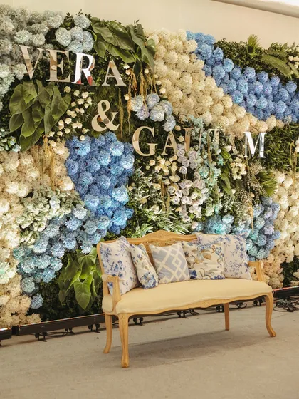 A beautiful floral wall of blue and white hydrangeas with the couple's names in silver, serving as a perfect photo backdrop and a central feature of the engagement party.