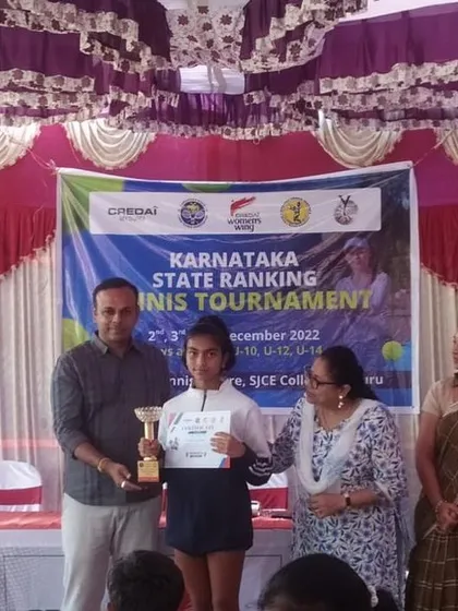 A young champion from our academy receives her trophy at the Karnataka State Ranking Tennis Tournament. We focus on creating a competitive yet supportive atmosphere for junior athletes to thrive.