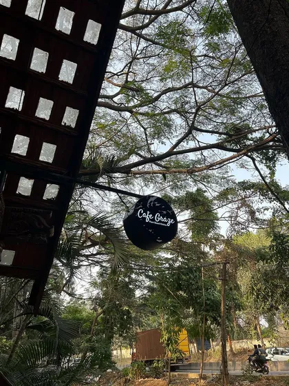 A view of our Cafe Graze sign hanging amongst the trees. This image captures the essence of our cafe: a natural, peaceful retreat tucked away from the hustle and bustle of the city.