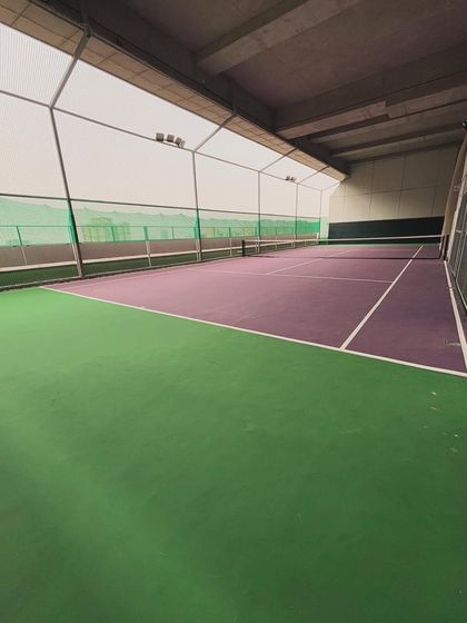 Our indoor tennis court, viewed from the side, showcasing its clean lines and professional setup.