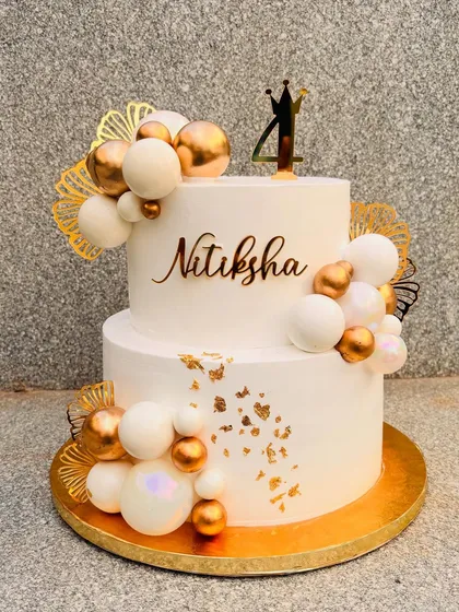 This was a 5-kilo beauty for a 4th birthday. I love creating these grand, elegant cakes with white and gold themes, using a mix of edible spheres, delicate gold leaf, and custom acrylic toppers to make it extra special.