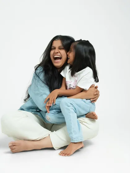 A mother and daughter sharing a moment of pure, uninhibited laughter in the studio. My clean, white backdrop ensures that nothing distracts from the genuine connection and happiness between them.