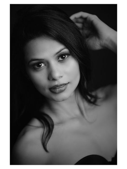 A close-up black and white portrait with a focus on emotion. The model's direct gaze is powerful and engaging.