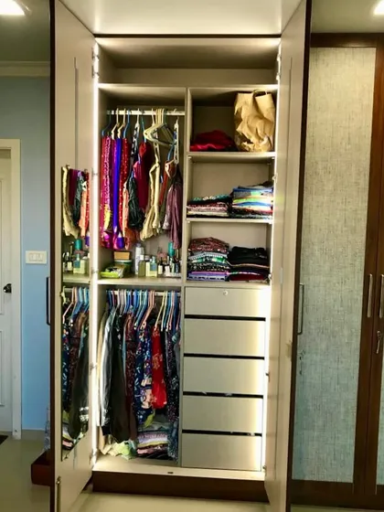 Another section of the cane door wardrobe, showing specialized storage for accessories and clothing. We believe in creating a place for everything.