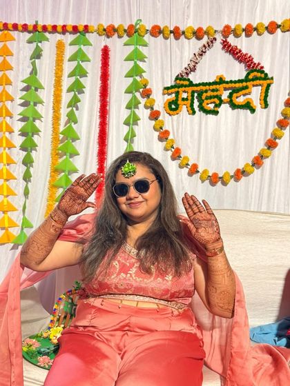 Posing for the camera in style. This guest is all smiles, showing off her full-hand mehendi design.