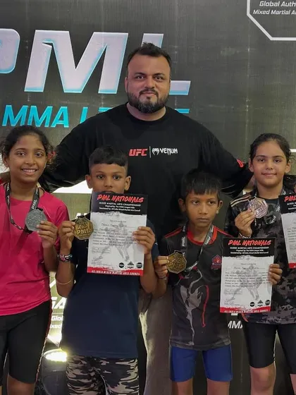 A proud coach with his team of national medalists. These kids dominated the under-12 category at the PML MMA Nationals, proving the effectiveness of our training program.