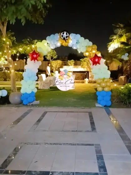 A football-themed balloon arch for an outdoor party at night.