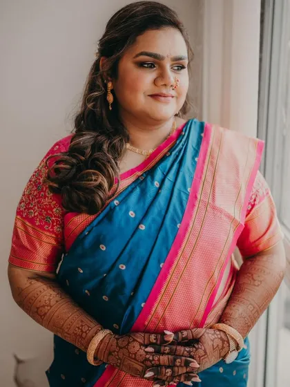 A candid moment of the bride, looking radiant. The dark stain of her full bridal mehendi is a key part of her stunning look.