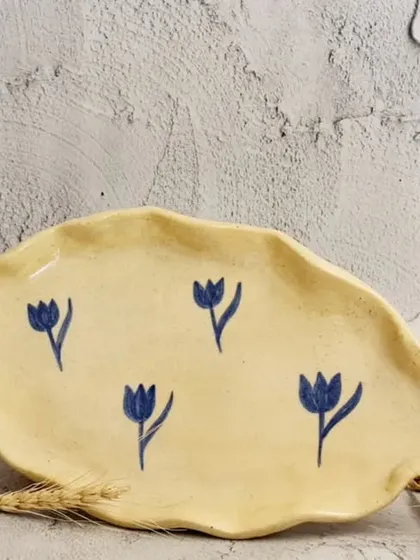 This small, hand-formed serving dish features a hand-painted blue lotus pattern. It's the perfect size for serving butter, a few pieces of sushi, or even as a catch-all dish for jewelry.