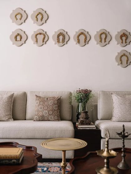 A collection of antique brass horse stirrups are mounted on the wall as a unique art installation, reflecting the home's theme of cherished memorabilia.