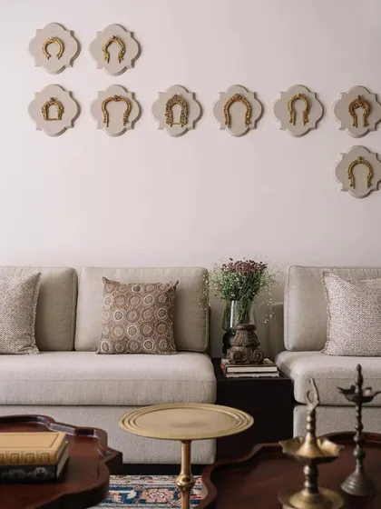 A collection of antique brass horse stirrups are mounted on the wall as a unique art installation, reflecting the home's theme of cherished memorabilia.