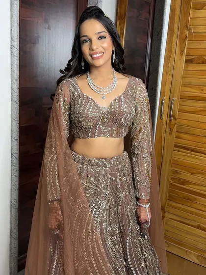 A full-length view of this elegant sangeet look. The hairstyle is a simple half-updo, keeping the hair off her face for dancing.