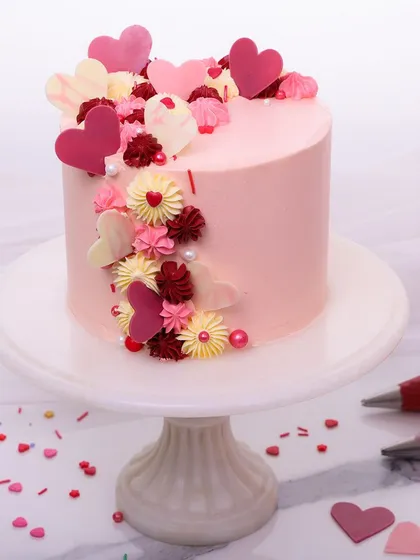 A full view of our heart-themed anniversary cake, set on a pedestal to showcase its romantic design.