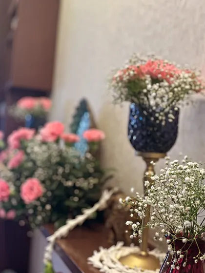 A close-up of an aesthetic decor detail. Pink carnations and baby's breath in elegant vases create a simple yet beautiful look, perfect for adding a touch of class to home celebrations.