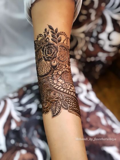 The start of a bridal design, showing the first few floral motifs being laid down on the arm.