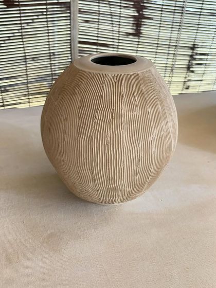 A collection of large, unglazed vases in various shapes and sizes. Each one is thrown on the wheel and showcases a different form, from classic curves to textured surfaces.