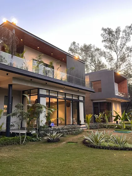 The front facade of 'The One', showcasing its layered volumes and the seamless integration with the surrounding garden. The design is a contemporary introduction to the historic neighborhood of Dera Mandi.