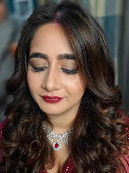 A close-up of this gorgeous reception glam. The look features a soft brown smokey eye, a deep berry-red lip, and beautiful, bouncy curls that frame the face perfectly.