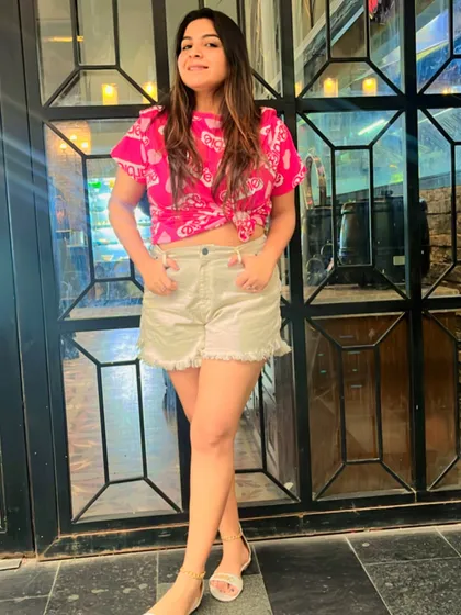 A casual day out look. I've paired a pink printed top with denim shorts for a comfortable and stylish summer outfit. The knot in the front adds a trendy touch.
