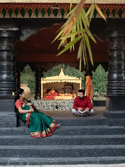 This wide angle shot captures the grandeur of the traditional setting. It shows the couple in a relaxed, regal pose, making their maternity photos feel truly epic and timeless.