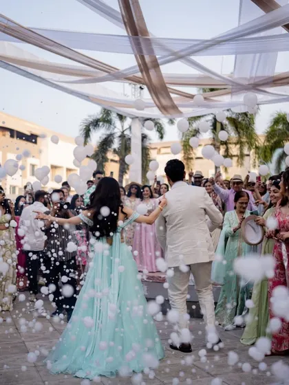 The couple's grand entrance into the carnival, surrounded by friends, family, and a cloud of playful bubbles.
