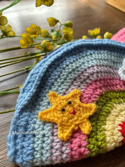A close-up of the adorable smiling star and cloud details on our kids' rainbow bag. These little touches are what make our children's accessories so magical.