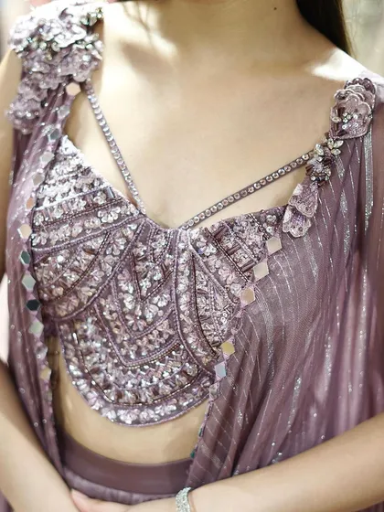 A close-up of the stunning mirror work and embellishments on this mauve dhoti-blouse set.