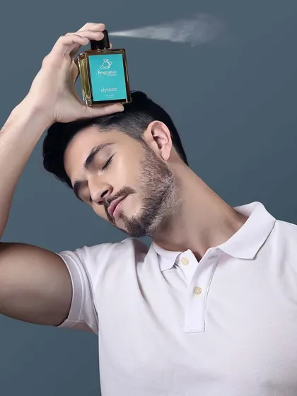 A creative shot of a model spraying perfume. This action shot is dynamic and engaging, perfect for social media or a website banner to capture attention.