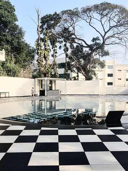 A bold checkerboard pattern defines the pool deck of this residence, creating a graphic and playful contrast with the surrounding architecture and landscape.