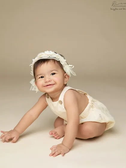 The beginning of crawling. This baby girl's smile shows her excitement as she starts to explore, a perfect moment to capture during a sitter session.