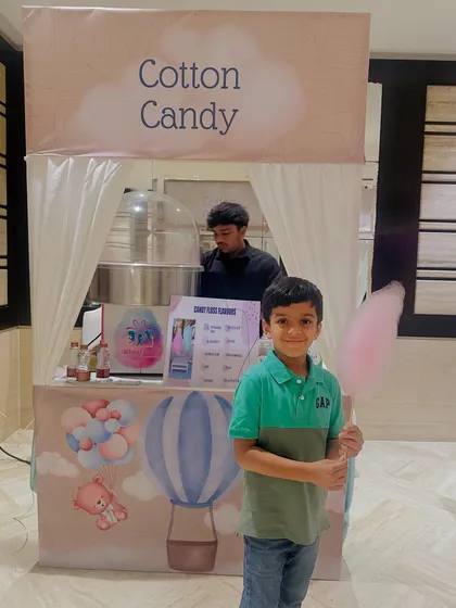 A happy customer at our themed cotton candy stall. We ensure our setups are as visually appealing as the treats are delicious.