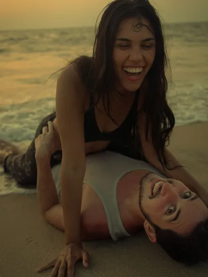 Photography isn't just about serious, moody shots. It's also about capturing pure, uninhibited joy, like this candid moment of laughter during a playful beach photoshoot at sunset.
