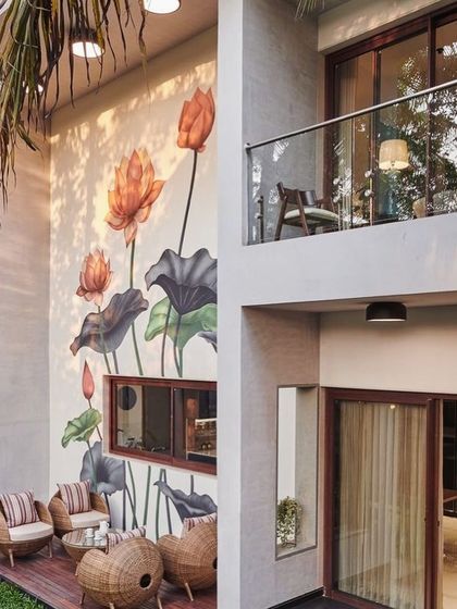 As part of a full architectural project, I designed this beautiful outdoor patio area. The space features a stunning hand-painted lotus mural on the exterior wall, a wooden deck, and a balcony, seamlessly blending indoor and outdoor living.