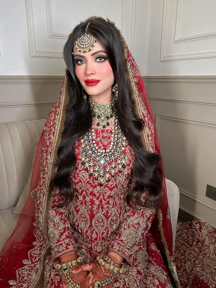 A portrait of a bride radiating confidence in her full bridal attire. The layered necklace and maang tikka are crafted to make you feel like the star of your wedding.
