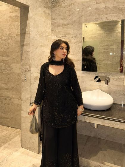 This pose shows the movement and drape of the black ethnic wear, giving a sense of the fabric and how it feels to wear it.