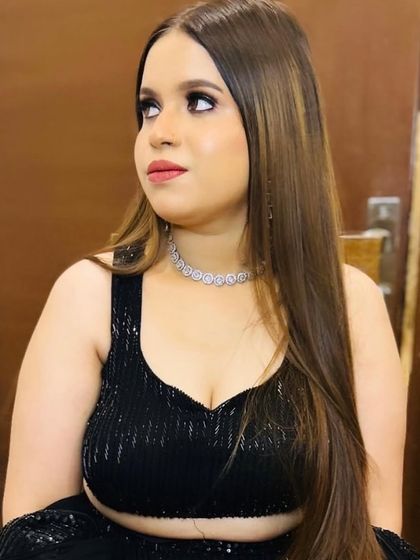 A side profile, showing the sleek straight hair and the sharp makeup look.