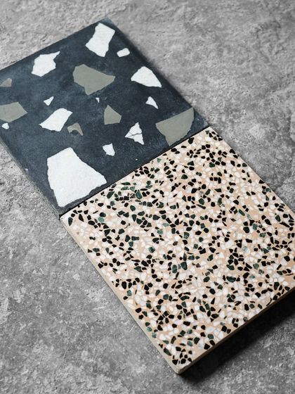 An angled view of the two contrasting terrazzo tiles, showing their texture and finish.