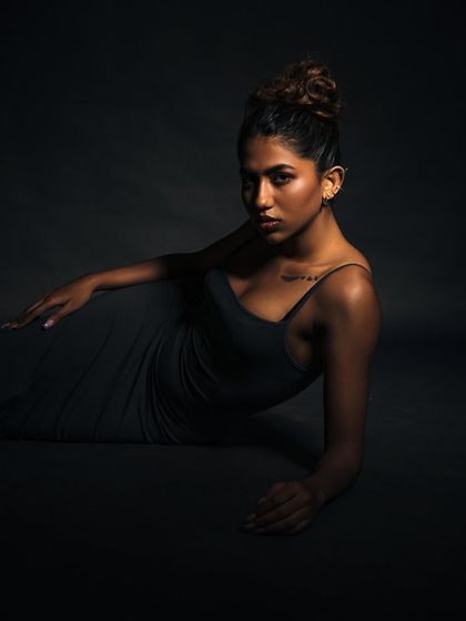 A low-angle shot with dramatic, low-key lighting. The shadows create a mysterious and cinematic mood, perfect for an artistic portrait.