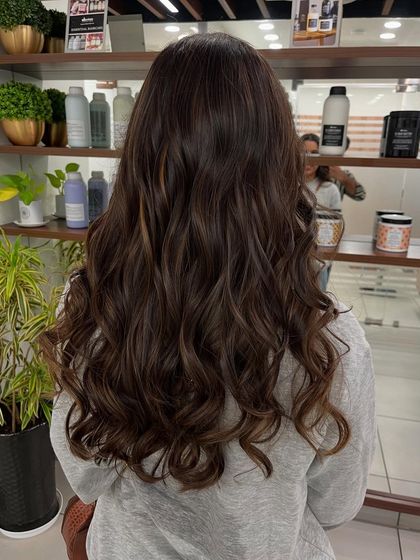 Caramel balayage with soft curls. This is a popular choice for adding warmth and dimension to dark brunette hair.