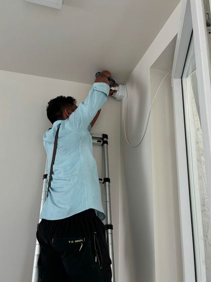 A technician installs a CP Plus Full HD camera near a window frame. We pay close attention to detail to ensure a clean and professional look.