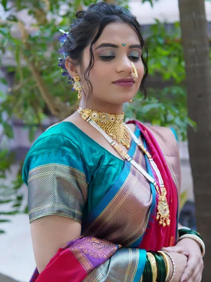 A soft, demure pose showing the beautiful eye makeup and hairstyle. The side profile highlights the contouring and the way the hair is styled to complement the overall look.