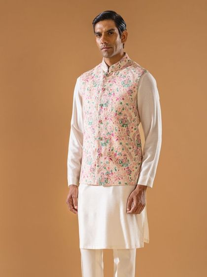 A pastel pink Jawahar jacket featuring whimsical, multi-colored embroidery of florals and elephants. This playful yet elegant piece is perfect for adding a touch of color to your festive wardrobe.