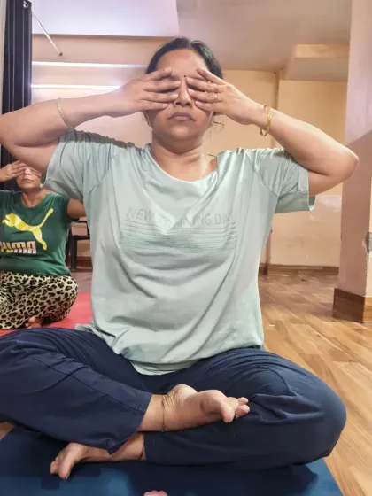 Two students practicing Bhramari Pranayama together in class. The humming sound helps to block out external distractions, guiding you inward.