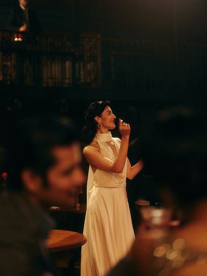 A solo singer captivates the audience in an elegant white gown. This shot highlights how individual character styling contributes to the richness of the overall campaign story.