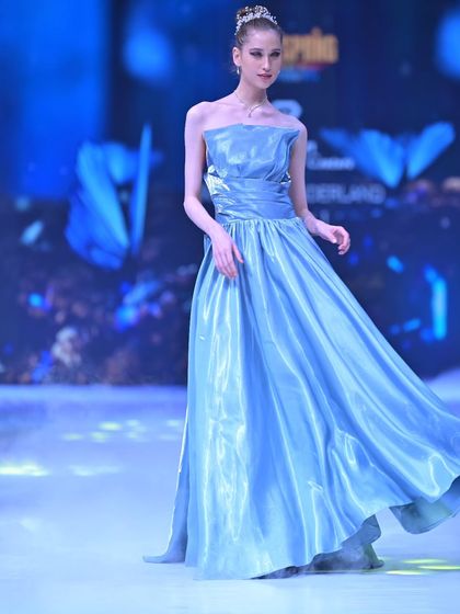 The movement of this blue satin gown is simply captivating, reflecting the light to create a liquid-like sheen on the runway.