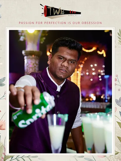 A bartender tops off a mocktail with a splash of soda, adding the final touch to a refreshing drink.