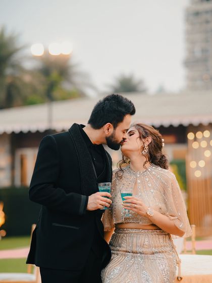 A sweet, spontaneous kiss shared by a couple during their outdoor celebration. This candid moment captures the romance and joy of their special day.