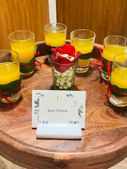 Shots of classic Aam Panna, a tangy and sweet raw mango drink. Served on a wooden tray, it’s a traditional Indian summer cooler that guests love.